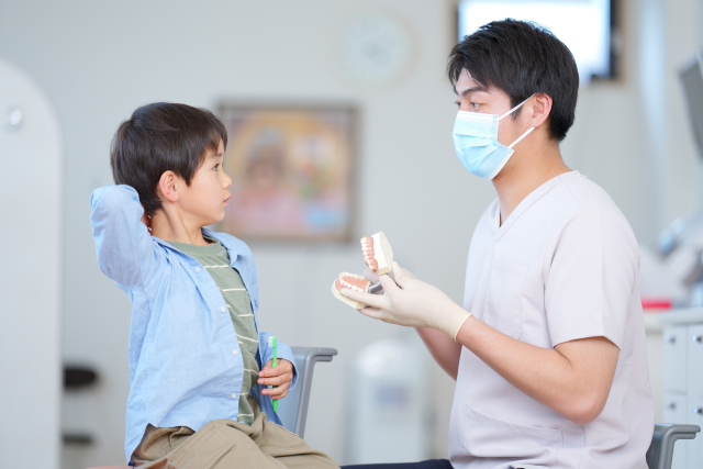 歯のケアについて説明を受ける子ども
